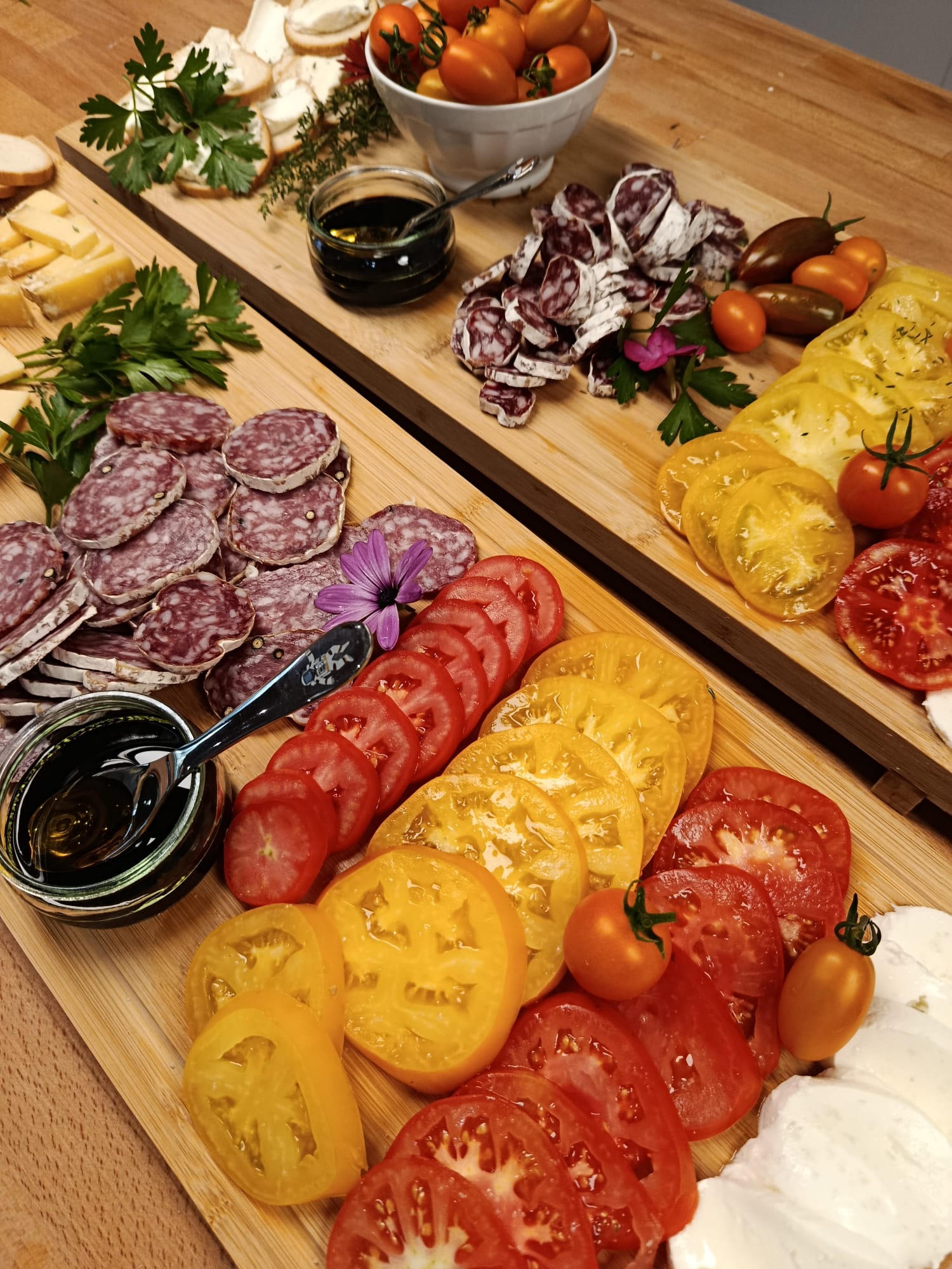 Planche gourmande avec tomates, charcuterie et fromages